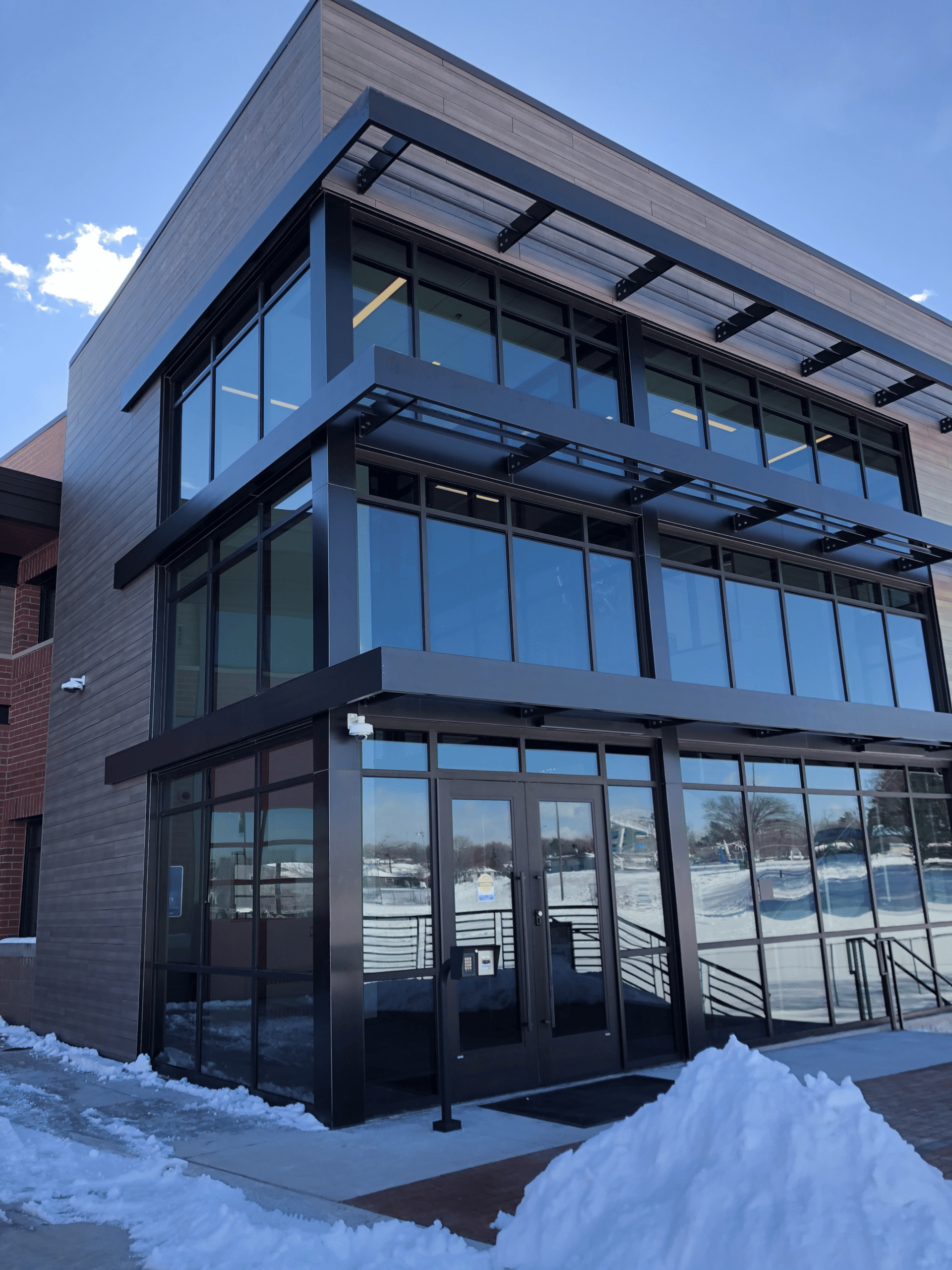 Professional window repair service by Horizon Glass in Colorado, showcasing a modern building entrance near me